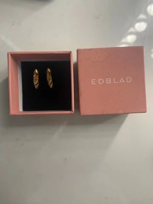 Guldiga hoops örhängen med nitar - Säljer dom här små guldiga örhängena som bara använts nån gång inann och är som nya fick dom för nått halvår sen dom passar till dom flesta outfitsen helt nya kostar dom 349 kr