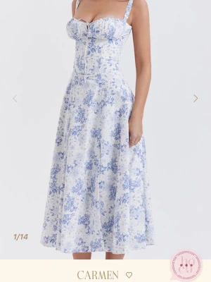 Blommig vit och blå klänning Carmen - Romantisk långklänning från Carmen i vit med blått blommönster. Klänningen har smala axelband, markerad byst med snörning framtill och en vacker, utsvängd siluett. Perfekt för sommarens alla tillfällen. Den är storlek M men om man drar in midjan med säkerhets nål eller likande så har den passat xs-s. Nypris 2000kr . Säg till om du vill diskutera pris. 💕