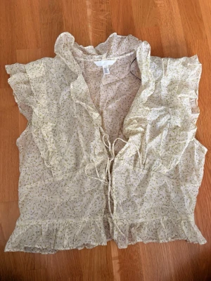 Blommig grön volangblus från H&M - Grön blus från H&M. Den ser mer grön ut i verkligheten än vad den gör på bilden. Knappast använd