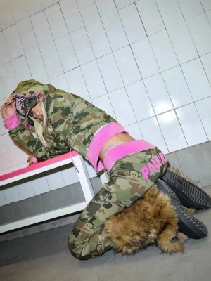 Paul Frank limited camo sett med rosa detaljer - Unika och limited lågmidjade mjukisbyxor med matchande zip hoodie i camomönster med rosa snören. Stora rosa bokstäver med märket 'PAUL FRANK' på baksidan. Skönt och unikt sett som är väldigt snyggt! Helt oanvänt!🥰
