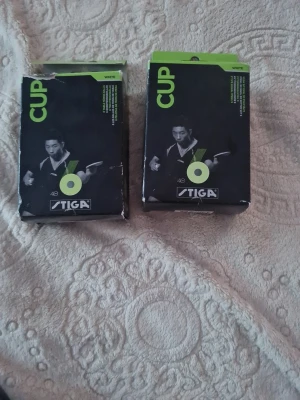 Stiga bordtennisbollar 6-pack vita - Två förpackningar med Stiga bordtennisbollar, 6-pack i varje. Bollarna är vita och kommer i originalkartong med grön och svart design. Perfekta för pingisträning eller match. Klassisk modell från Stiga. Bollarna är i bra skick, förpackningarna är lite slitna då dem har varit i en låda. 