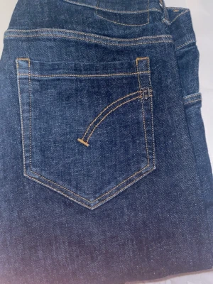 Blå jeans från George med kontrastsömmar - Säljer ett par klassiska blå jeans från George med raka ben och snygga kontrastsömmar i gult. Jeansen har fem fickor, bälteshällor och en läderpatch bak i midjan. Materialet är slitstark denim i bomull. Perfekta till vardagslooken!