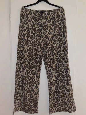 Leopardmönstrade byxor  - Vida byxor i leopardmönster, storlek M. Har fått byxorna uppsydda så de går ned till marken på mig som är 160cm.   Kom gärna med bud!✨