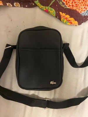 Svart axelväska från Lacoste - Priset kan diskuteras vid snabb affär