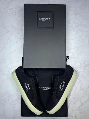 Svarta Saint Laurent sneakers - Säljer dessa ysl skor i fint skick, använt ett fåtal gånger🤩 Allt på bild följs med.😇 Hör av er vid snabbaffär samt funderingar, kan tänka mig gå ner i pris vid snabbaffär🙌🏻