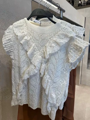 Vit stickad topp med volang från Zara - Supersöt cremevit stickad topp från Zara med korta ärmar och dekorativa volanger framtill💗