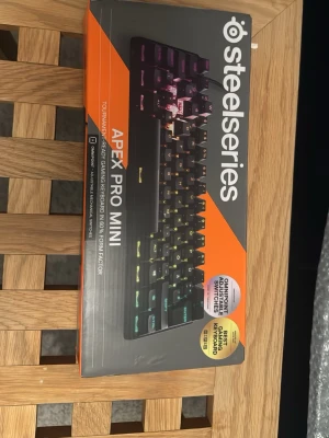 SteelSeries Apex Pro Mini tangentbord - SteelSeries Apex Pro Mini är ett kompakt mekaniskt tangentbord med RGB-belysning och svarta tangenter. Tangentbordet har OmniPoint 2.0-switchar och är designat för gaming med 60% formfaktor. Perfekt för dig som vill ha ett litet och snabbt tangentbord.