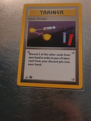Item Finder 1st Edition  - Säljer ett original Pokémonkort av typen Trainer, Item Finder från Wizards of the Coast. Kortet har gul ram, färgglad framsida och klassisk baksida med Pokéball och blå bakgrund. Perfekt till samlingen för dig som gillar Pokémonkort!