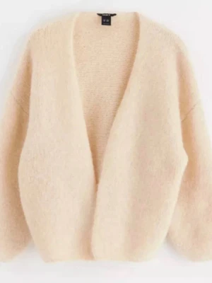 Beige fluffig kofta från Lindex - Mysig beige kofta med fluffig textur och avslappnad passform. Koftan har djup V-ringning och breda ärmar, perfekt för lager på lager. Tillverkad i mjukt material som känns lyxigt och trendigt. Går ej att köpa längre, strl M/L kan diskutera pris!