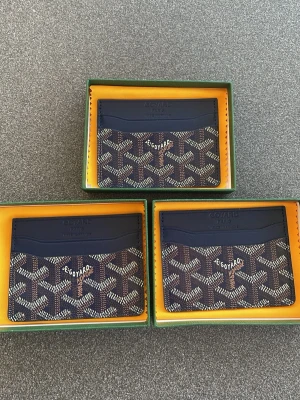 Goy4rd plånbok - Snygg korthållare i mörkblått med klassiskt mönster och logga framtill. Tillverkad i läder och canvas, perfekt för kort och ID. Kommer i original grön ask 245kr styck