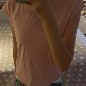 Ljusrosa Träningströja från SOC - Säljer en ljusrosa träningströja från SOC med korta ärmar och rund hals. T-shirten är gjord i mjuk polyester och har en enkel, clean look utan mönster eller detaljer. Det står att den är stl 146/152, men passar mig som har XS-S i vanliga fall. Inte använd mycket så i bra skick. Hör gärna av er om frågor!❤️