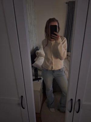 Ljusblå bootcut jeans från Lager 157 - Säljer ett par ljusblå bootcut jeans från Lager 157. med klassisk femficksdesign och dragkedja. Jeansen har en lätt slitning vid ena benet och är tillverkade i bomullsdenim. Perfekt för dig som gillar en avslappnad och trendig look.