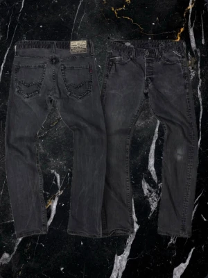 Svarta Replay jeans med bakficka - Snygga svarta jeans från Replay med klassisk femficksdesign och tydlig logotyp på bakfickan. Jeansen har en mörk tvätt och detaljerad söm på bakfickan samt Replay-märke i läder baktill i midjan. Perfekta för en trendig och avslappnad stil.finns ett litet hål kolla bild 4