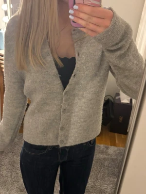 Ljusgrå stickad kofta - Mysig ljusgrå stickad kofta i ullblanding. Kontakta mig vid frågor!