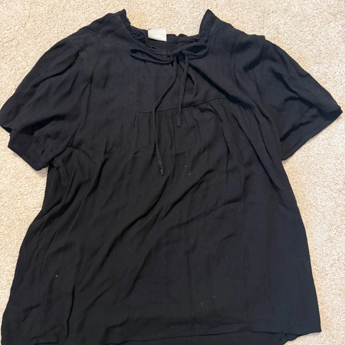 Svart blus med knytband i halsen