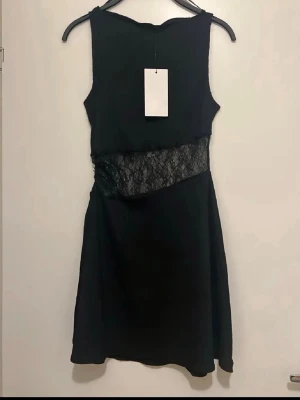 Zara spetsklännig - Snygg brun handväska från Zara i slätt läder med guldfärgade metalldetaljer och ett dekorativt spänne framtill. Väskan har en stadig axelrem och klassisk, rektangulär form. Perfekt för dig som gillar stilrena accessoarer med exklusiv känsla.