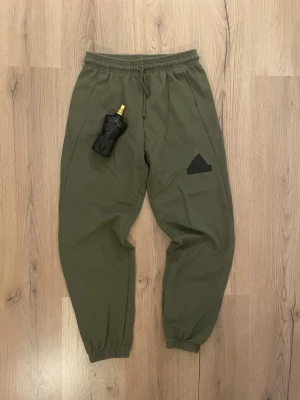 Sköna Mjukis Byxor 👖 Från ADIDAS!✨ stl - 164 - 💚 Olivgröna mjukisbyxor från Adidas – stl 164 💚  Supersköna & stretchiga 😍 Perfekta till skolan, chill eller träning 🏃‍♀️✨  📏 Midja: 70 cm 📏 Ytterben: 92 cm 📏 Innerben: 64 cm 📏 Bensbredd: 40 cm (Materialet är väldigt stretchigt!)  💸 Pris: 199 kr  Snygg färg + skön passform = perfekt kombo 💚🔥Först Till Kvarn!🏃‍♀️‍➡️🏃‍♀️‍➡️