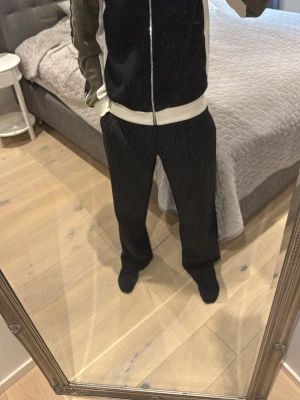 Svart och olivgrön hoodie från Emporia Armani - Säljer en svart hoodie från Ea7 med olivgröna ärmar och vita detaljer. Dragkedja framtill, huva och en stor vit logga på ryggen. Perfekt för dig som gillar streetwear och sportig stil.