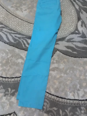 Turkosa raka jeans - Säljer ett par turkosa jeans med rak passform. Jeansen har klassisk design med fickor bak och är tillverkade i ett mjukt material som känns bekvämt. Perfekta för dig som vill sticka ut med färg i vardagen. PRIS KAN DISKUTERAS!