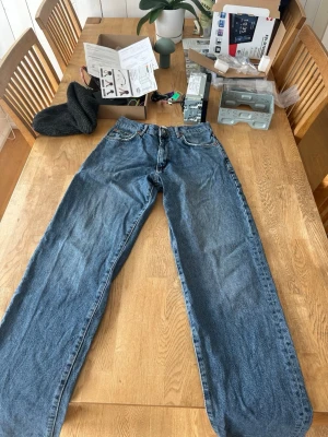 Blå raka jeans från Levi's - Säljer ett par klassiska blå woodbird jeans med rak passform och fem fickor. Jeansen har normal midja, dragkedjegylf och är tillverkade i slitstark denim. Perfekta för en avslappnad och tidlös stil.