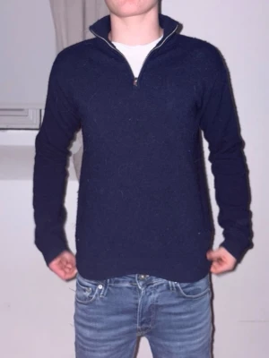 Mörkblå halvzip tröja - Mörkblå stickad tröja med halvzip. Perfekt för dig som gillar att se stilren ut men inte vill lägga en förmögenhet på en tröja. Som ni kan se på bilder så är tröjan nopprig men det går att ta bort med maskin. Tveka inte på att höra av er. Mvh Resellclts. Storlekn står att den är 146-152 men stämmer ej. Hoodie sitter som xs. 