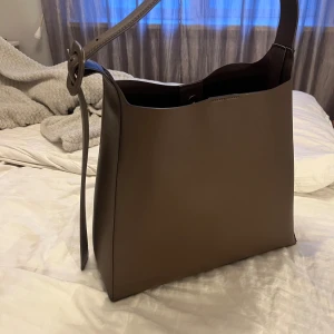 Brun axelväska från mango - Använt ungefär 5 ggr, datorn passar perfekt i den också!! Inga defekter 