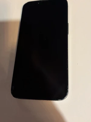 IPhone 14 - Säljer en svart iPhone med stilren design och dubbla kameror på baksidan. Telefonen har en platt framsida och bakstycke i glas med Apple-loggan. Metallramen ger en modern känsla och knapparna sitter på sidan. Perfekt för dig som gillar snygg och enkel teknik. Det ända är att mobilens mikrofon kan krångla ibland. Men pratar min igenom mobil, finns det aldrig problem endast på längre distans med högtalare på. Batericapacitet ligger på ungefär 85%. 128gb, möts bara upp för mobilen. Pris kan diskute