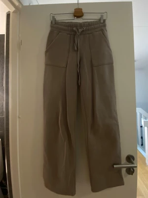 Beige mjukisbyxor med raka ben - Säljer ett par beige mjukisbyxor med breda raka ben och stora fickor både fram och bak. Storlek XS men passar även S. 