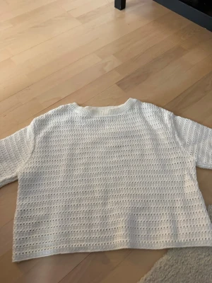 Vit stickad tröja från MNG - Säljer en vit stickad tröja från MNG i storlek S. Tröjan har ett luftigt hålmönster, rund halsringning och ribbade muddar. Perfekt till jeans eller kjol för en fräsch look.