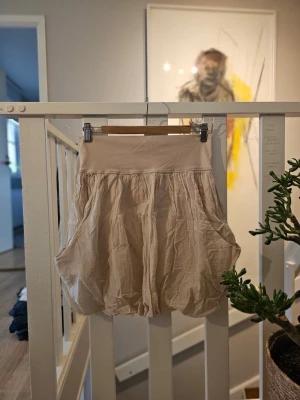 Ny köpt Beige ballongkjol - Säljer en beige ballongkjol MED! fickor. Aldrig använd, ny skick med tags kvar . Kjolen har en avslappnad passform och är gjord i ett tunt, luftigt bommullsmaterial. Perfekt för dig som gillar en unik och bekväm stil.