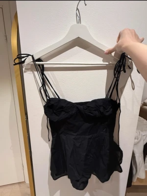 Topp från zara - Fin korsett liknande topp från Zara! Den sitter tajt upptill och går sedan ut nere. Superfin passform och har knytbara band och en dragkedja på sidan! Den ser lite skrynklig ut på bilderna men den har inga defekter😚