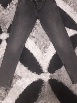 Svarta skinny jeans Tommy Hilfiger - Snygga svarta skinny jeans från Tommy Hilfiger med klassisk femficksdesign och bälteshällor. Jeansen har en smal passform och är tillverkade i ett stretchigt denimtyg som sitter tajt längs benen. Perfekta för en trendig och avslappnad look.