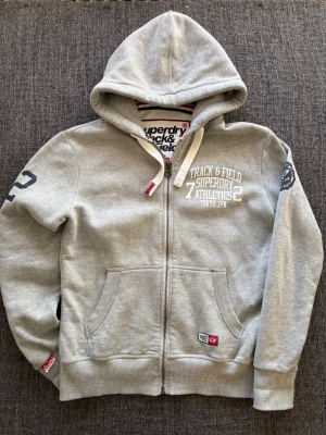 Superdry zip hoodie ~ sällsynt  - Säljer en eftertraktad Superdry tröja i väldigt bra skick | storlek L (passar även M ) och passar perfekt nu till våren. Kan även gå ner lite i pris vid snabb affär  Obs vid frågor tveka inte😊