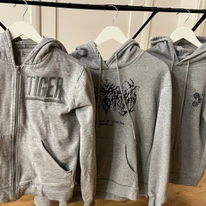 Gråa hoodies med tryck - Tre gråa hoodies i olika modeller, alla med huva. Två lite tunnare material och en tjockare med dragkedja. Olika märken, säljs alla 3 tillsammans 
