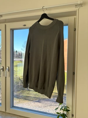 Grå stickad tröja Massimo Dutti - Snygg grå/grön stickad tröja från Massimo Dutti i 100% bomull. Tröjan har rund halsringning, ribbade muddar vid ärmslut och nederkant samt en klassisk, avslappnad passform. Perfekt basplagg för lager på lager och enkel att matcha. Väldigt snygg till våren!