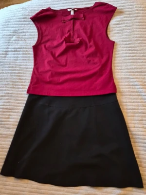 Set: Svart A-linjeformad kjol och topp stl S - En klassisk svart kjol i A-linjeform med enkel design och hög midja. Kjolen är kort och har en diskret söm över höften. Perfekt att matcha med olika toppar för en stilren look. Toppen från H & M 