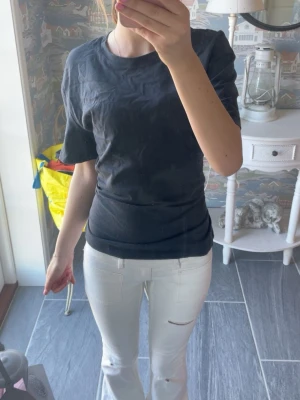 Svart t-shirt med knyt i ryggen - En jätte fin t-shirt som man kan knyta där bak, tyvärr tycker jag den sitter lite stort på mig! Färgen är lite svart/grå/mörkblå.
