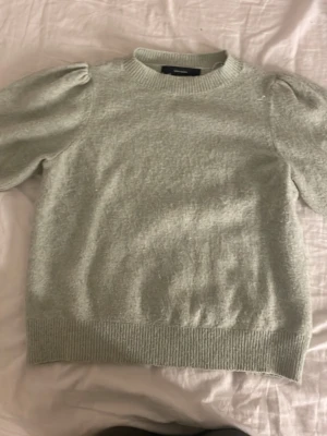 Ljusgrön stickad tröja Vero Moda - Säljer en ljusgrön stickad tröja från Vero Moda med puffärmar och ribbade muddar vid hals, ärmslut och nederkant. Tröjan har en mjuk och mysig känsla, perfekt för dig som gillar en enkel men trendig look.
