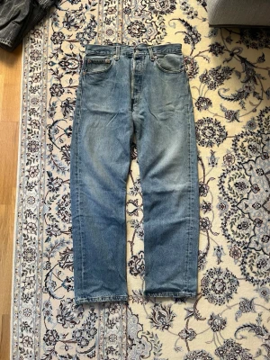 80 talet Levi's jeans - Klassiska blå Levi's jeans med rak passform från 80-talet. Jeansen är i otroligt bra skick för dess ålder. Tillverkade i slitstark denim