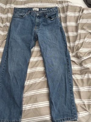 Mörkblåa jeans från Pull&Bear, wide leg  - Klassiska blå jeans från Pull&Bear med baggy passform och fem fickor. Jeansen har normal midja, dragkedjegylf och är tillverkade i slitstarkt denimtyg. Perfekta för en avslappnad och tidlös stil.