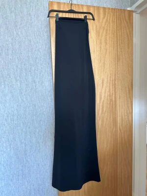 NA-KD maxiklänning -svart, axelbandslös, elegant - Svart maxiklänning från NA-KD i en väldigt fin och stilren modell. Axelbandslös med en draperad detalj framtill som ger ett snyggt fall. Enkel men väldigt elegant. passar perfekt till fest, middag eller sommar. Sitter fint på och känns både bekväm och smickrande.