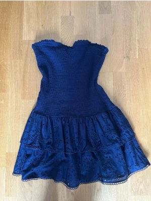  axelbandslös kortklänning - Söt marinblå axelbandslös klänning med smockad överdel och volangkjol storlek xl men passar också L
