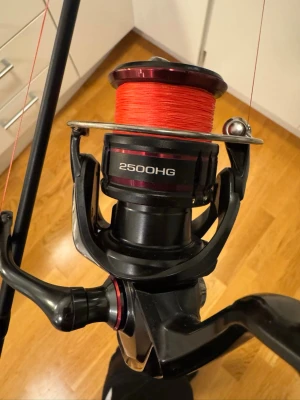 Westin fiskespö med Shimano 2500HG rulle - Säljer ett svart fiskespö från Westin med en Shimano 2500HG rulle. Rullen har röd lina och spöt är gjort i kolfiber med tydlig Westin-logga. Perfekt för dig som gillar fiske och vill ha bra utrustning.