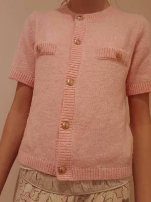 Ljusrosa tröja - Superfin ljusrosa stickad kofta med korta ärmar. Koftan har guldfärgade knappar och det är ett super skönt och mjukt plagg som inte sticks. 💗Perfekt för den som älskar söta och rosa kläder! 😻40 kr+frakt💰