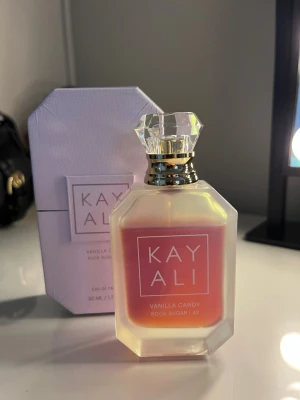 Kayali Vanilla Candy Rock Sugar 42 parfym - Kayali Vanilla Candy Rock Sugar 42 är en Eau de Parfum i en lyxig glasflaska med kristallkork. Doften har en söt och gourmand karaktär med inslag av vanilj och sockrig karamell. 50ml, skulle säga att det är ca 85-90% kvar i flaskan. 