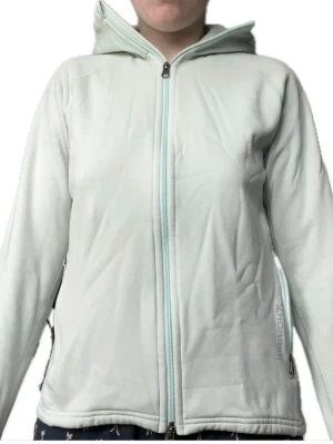 Houdini fleece hoodie 💚 mintgrön (Power Houdi) – trendig & varm - Snygg och funktionell fleecejacka från Houdini. Liknar modellen Power Houdi – en populär och kvalitativ hoodie/fleece från Houdini.  Ljus mintgrön färg (färg som inte säljs längre), med dragkedja hela vägen, huva och fickor med dragkedja. Perfekt både till vardag och som mellanlager när det är kallt.  Materialet är mjukt, stretchigt och värmande – typ fleece. Har även tumhål längst ut på ärmarna vilket gör den extra skön och praktisk.  Använd men i bra skick! Inga hål eller större slitningar.