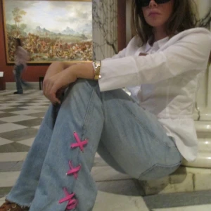 Blåa jeans med detalj! - Blåa jeans med snörningsdetalj nertill! Relativt hög midja men snygga ”oversized”. Modellen är ca 165 cm lång. Går självfallet att byta snören själv!!!!