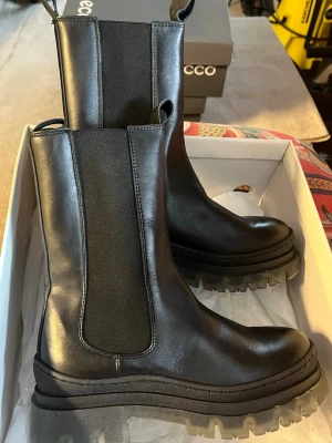 Svarta chunky Chelsea boots från Ecco - Säljer ett par svarta Chelsea boots, använda en eller två gånger annars har de bara liggit runt så fortvarande sprillans nya. Storlek 36 och kommer ej i orginal förpackning!