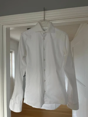 Vit skjorta från Oscar of Sweden  - Stilren vit skjorta från Oscar of Sweden  med klassisk krage och super slim fit. Skjortan har lång ärm och en rak passform och är wrinkle free. Nypris: 1499kr storleken är som XS