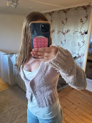 Ljusrosa stickad kofta med knappar - Säljer ljusrosa stickad kofta.